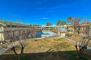 A courtyard with a swimming pool, surrounded by buildings with a simple architectural style. - Milledgeville|King Bed|Smoking (Milledgeville, GA)