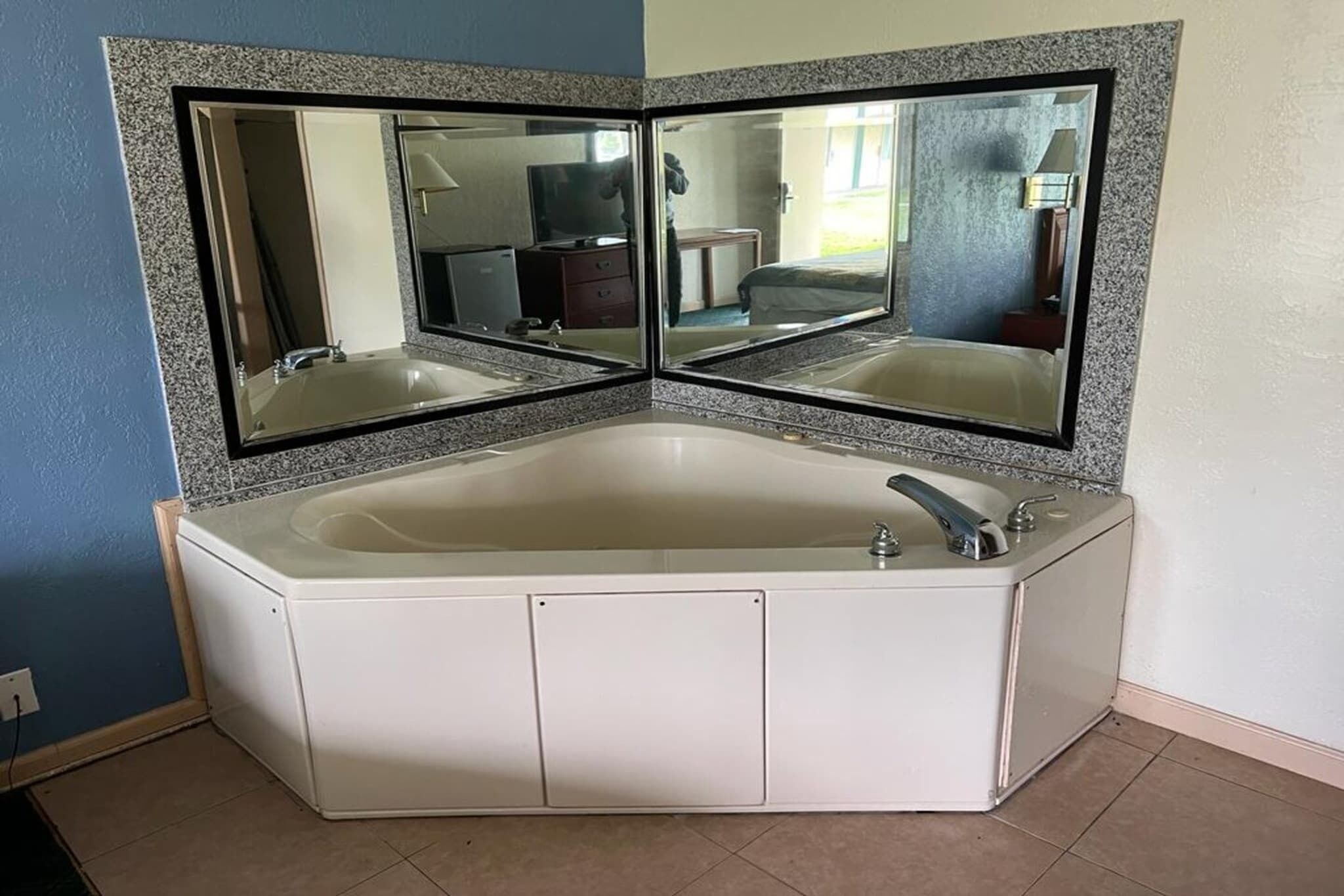 Ein Badezimmer mit Eckaufteilung, einer freistehenden Badewanne, einem doppelten Spiegel und einem Waschbecken.