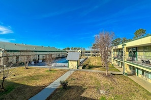 A building with a green roof, a swimming pool, and a covered outdoor area. - Full Bed|Smoking|Milledgeville (Milledgeville, GA)