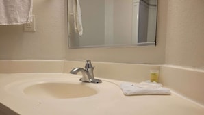 A bathroom with a sink, mirror, and towel. - 2 Full Beds Non-Smoking (Minonk IL)