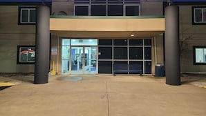 A building entrance with a covered walkway, large windows, and a bench. - 2 Full Beds Non-Smoking (Minonk IL)