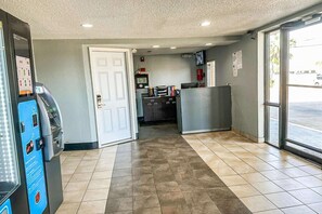 Siisti ja moderni sisustus, jossa on itsepalvelupiste, ovi, joka johtaa keittiötilaan, ja suuri ikkuna, josta tulee runsaasti luonnonvaloa.