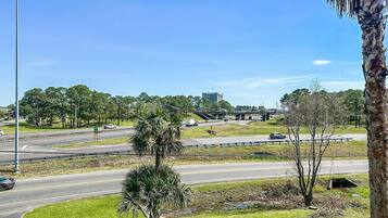 A highway interchange with multiple lanes, palm trees, and a clear blue sky.