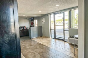 Un interior moderno y limpio con un mostrador de recepción, un ventanal grande y una unidad de aire acondicionado visible.