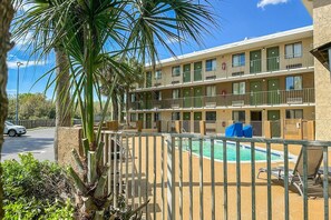 Ein mehrstöckiges Motel mit Schwimmbad, Balkonen und einem eingezäunten Bereich.