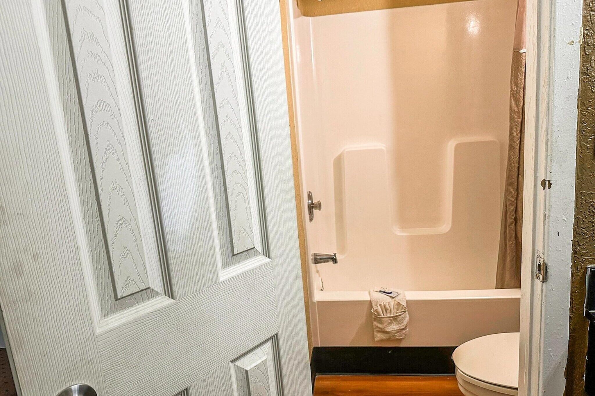 A bathroom with a bathtub, toilet, and a shower curtain.