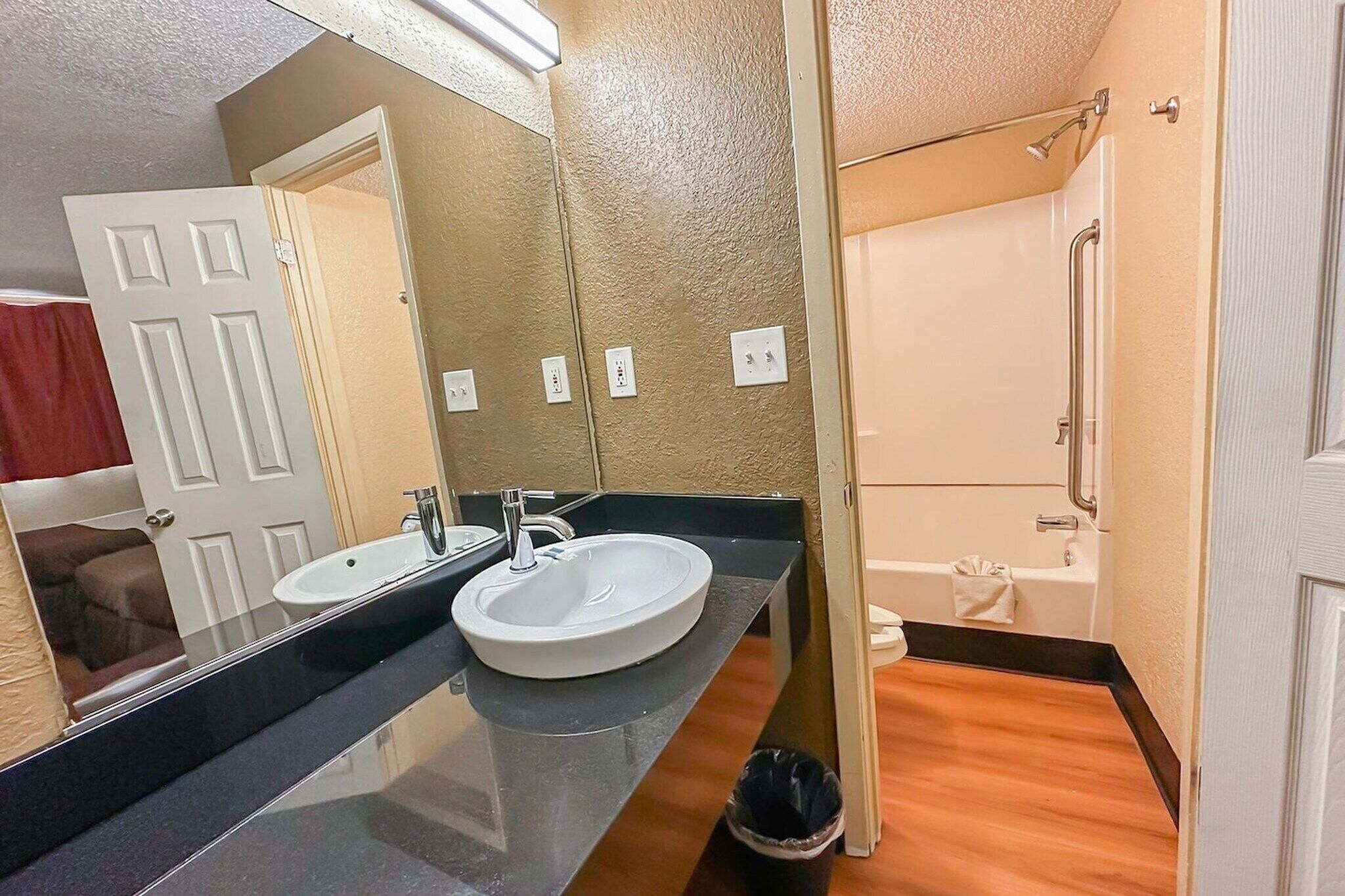 A bathroom with a double sink, a bathtub, and a shower.