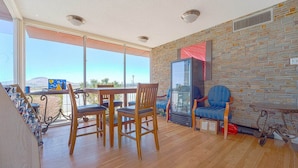A room with a dining table, chairs, a fireplace, and a large window with a view. - King Bed|Non-Smoking (Mojave CA)