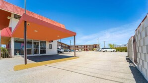 A motel with a red awning, a covered parking area, and multiple cars parked in the lot. - 2 Full Beds|Non-Smoking (Mojave CA)