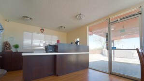 A reception area with a wooden counter, a clock, and a window with blinds. - 2 Full Beds|Non-Smoking (Mojave CA)