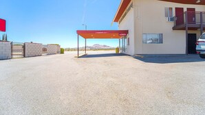 A building with a red awning labeled 'Lobby' and a car parked in front. - 2 Full Beds|Non-Smoking (Mojave CA)