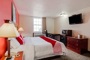 A hotel room with a bed, desk, TV, and a dresser. - King Bed Accessible|Nsmk (Morton IL)