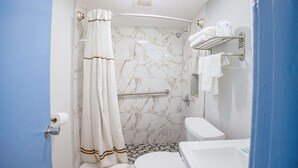A bathroom with a shower, toilet, and bathtub. - Queen Bed|Kitchenette|Non-Smoking (Merritt Island FL)