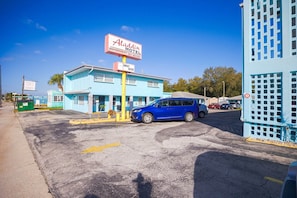 A motel with a sign reading 'Aladdin Motel,' a blue building, and a parked car.