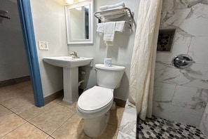 Un baño con inodoro, lavabo y ducha.