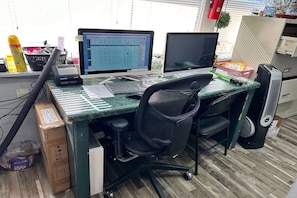 A workspace with two monitors, a keyboard, a mouse, a chair, a desk, and a box. - 2 Full Beds|Non-Smoking (Merritt Island FL)