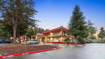 A building with a red roof, multiple floors, and a fire lane in front.