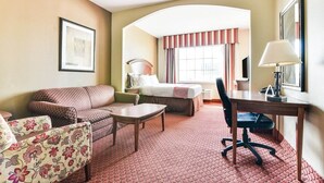 Ein Hotelzimmer mit Sofa, Bett, Schreibtisch und Stuhl.