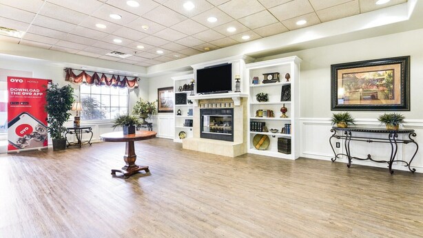 Un'ampia hall dell'hotel con camino, televisione e scaffali decorati.