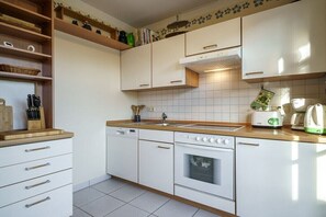 Eine Küche mit weißen Schränken, einem Geschirrspüler, einem Backofen und einem Toaster.