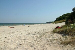 A sandy beach with people, some lying down, and a few walking. - Holiday home with 2 bedrooms (Putgarten)