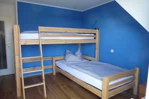 A bunk bed room with blue walls and wooden flooring. - in the Boddenblick house, Apt. 32 (Zingst)