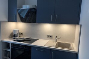 A modern kitchen with a built-in oven, a coffee maker, and a sink. - in the Boddenblick house, Apt. 32 (Zingst)