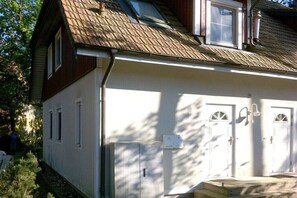A two-story building with a sloped roof, white exterior walls, and a small front porch with steps. - Forest settlement "Time Out" (Prerow)