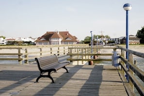 A wooden pier with a bench, a fence, and buildings in the background. - Holiday apartment with 2 bedrooms (Zingst)