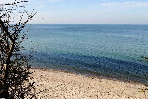 Ein Strand mit klarem Wasser und sandigem Ufer.