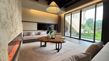 Suite estudio de lujo, 1 cama King size, baño privado, vista a la montaña | Área de sala de estar