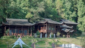 A traditional building with multiple levels and a wooden fence in the foreground.