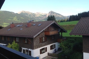 Ein traditionelles Chalet mit schrägem Dach, mehreren Fenstern und einem Balkon.