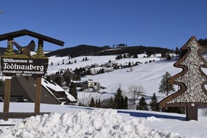 A snow-covered landscape with a sign welcoming visitors to Todtnauberg, featuring a wooden structure and a snowflake-shaped decoration. - Holiday apartment with 1 bedroom (Todtnauberg \/ Schwarzwald)