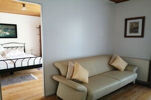 Ein Schlafzimmer mit einem Bett, einem Sofa, einem Heizkörper und einem gerahmten Bild an der Wand.