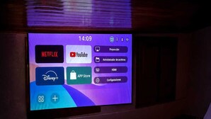 A television screen displaying a media application interface with options like Netflix, YouTube, and Disney+. - El Refugio De Los Pomares (la romana)