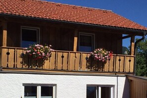 A building with a balcony, wooden railings, and flower baskets. - Holiday apartment in Oberstdorf with Wi-Fi (Oberstdorf)