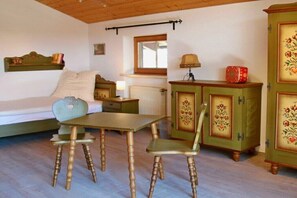 Ein Zimmer mit einem Bett, einem Tisch mit Stühlen, einem Schrank und einem Fenster.