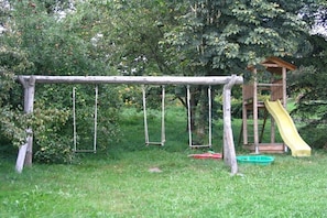 Ein Spielplatz mit Schaukeln und einer Rutsche.