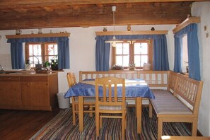 Ein gemütliches Zimmer mit einer hölzernen Bank, einem Tisch und einer Küchenzeile.