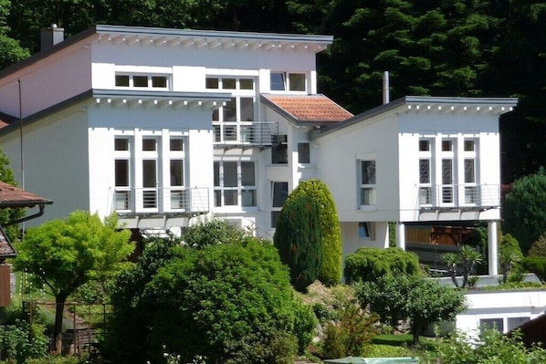 A two-story building with a balcony, surrounded by greenery. - "A" in the house with panoramic view (Ettenheim)