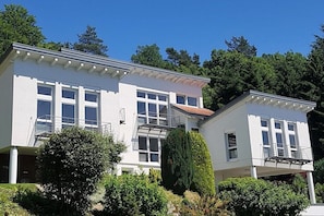 A two-story building with a balcony on the upper floor, surrounded by greenery. - "A" in the house with panoramic view (Ettenheim)