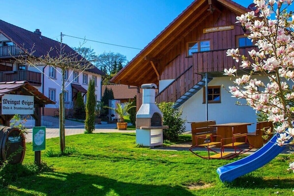 Ein Holzgebäude mit einem Schild, auf dem 'Weingut Geiger Wein & Brauerei' steht.