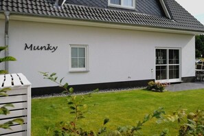 Ein weißes Gebäude mit dem Schriftzug 'Munky', einem Fenster und einer Tür.