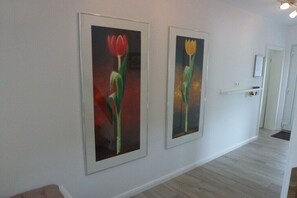Ein Flur mit zwei gerahmten Gemälden von Tulpen an der Wand.