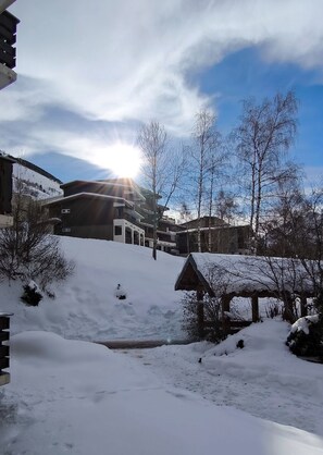Schneebedeckte Landschaft mit einem mehrstöckigen Gebäude und blauem Himmel.