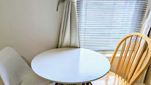 A round table with two chairs, a window with blinds, and a curtain. - Contractor Business Family Stay Near Southampton Airport 1BR (Eastleigh)
