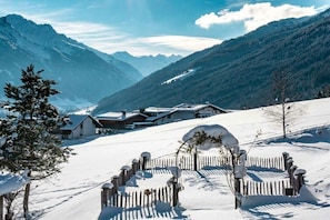 A snow-covered mountain village with wooden houses and a snow-covered fence. - Holiday apartment with 1 bedroom (Telfes im Stubaital)