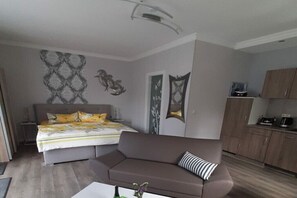 Ein Schlafzimmer mit Bett, Sofa, Nachttisch und Beistelltisch.
