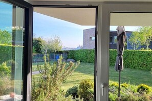 Ein modernes Gebäude mit Glastür und Zugang zu einem gepflegten Garten.